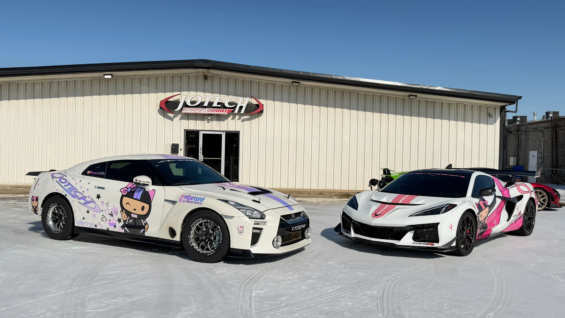 Two custom Jotech Motorsports cars, a white Nissan GT-R and a white Corvette C8 Z06 with anime liveries, parked outside the shop.