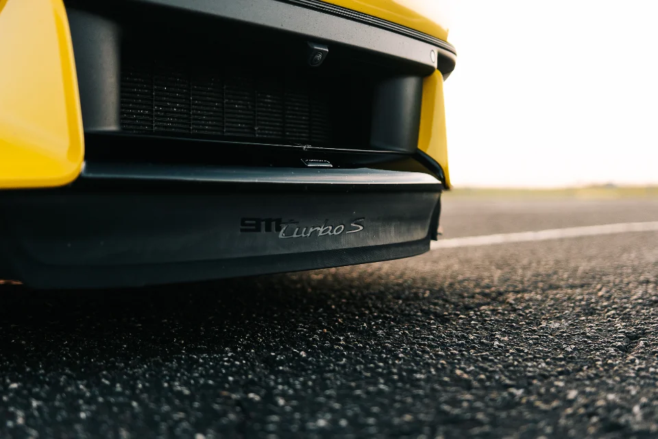 Close-up of the front bumper and '911 Turbo S' badging on a yellow Porsche 911 Turbo S.