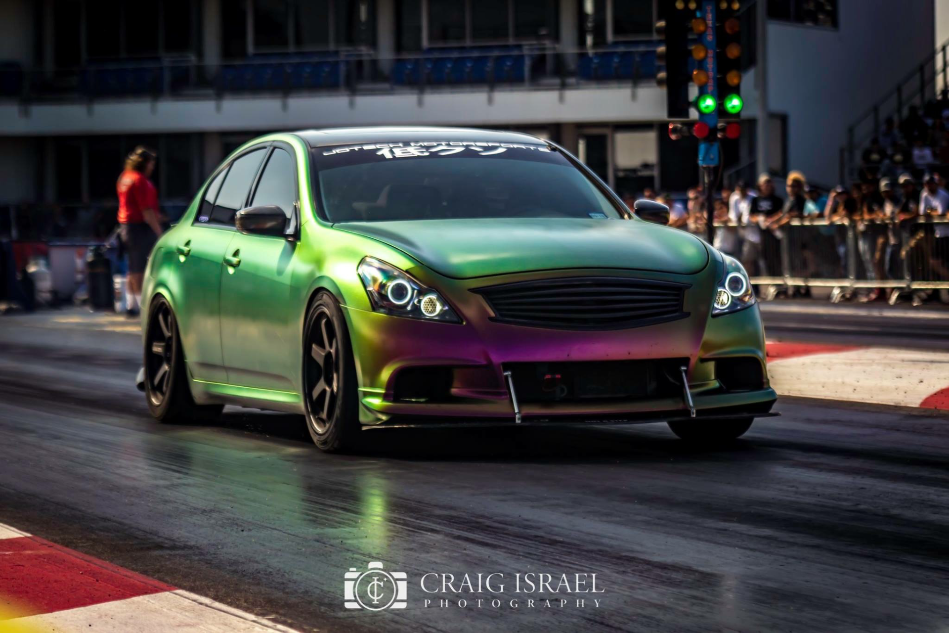 Chameleon wrapped Infiniti G37 sedan at the drag strip with the Christmas tree lit green, ready to launch.