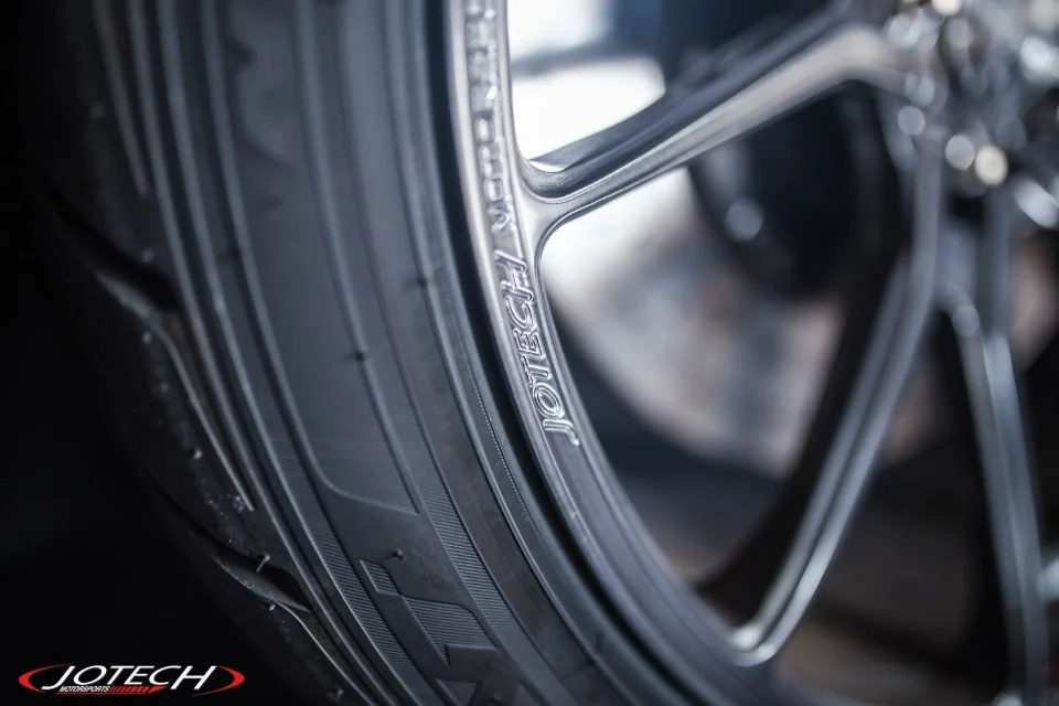 Close-up of a Jotech Motorsports branded wheel and tire, showcasing the detail of the rim and tire tread.