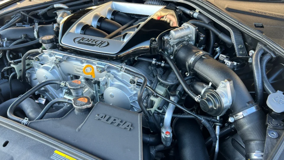 Close-up view of a Jotech-tuned Nissan GT-R VR38DETT engine bay with custom intake manifold and boost piping.