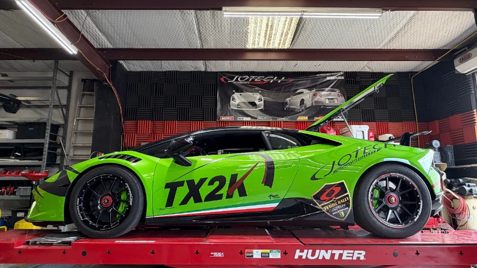 A bright green Lamborghini Huracan with TX2K livery on a Hunter dyno at Jotech Motorsports.