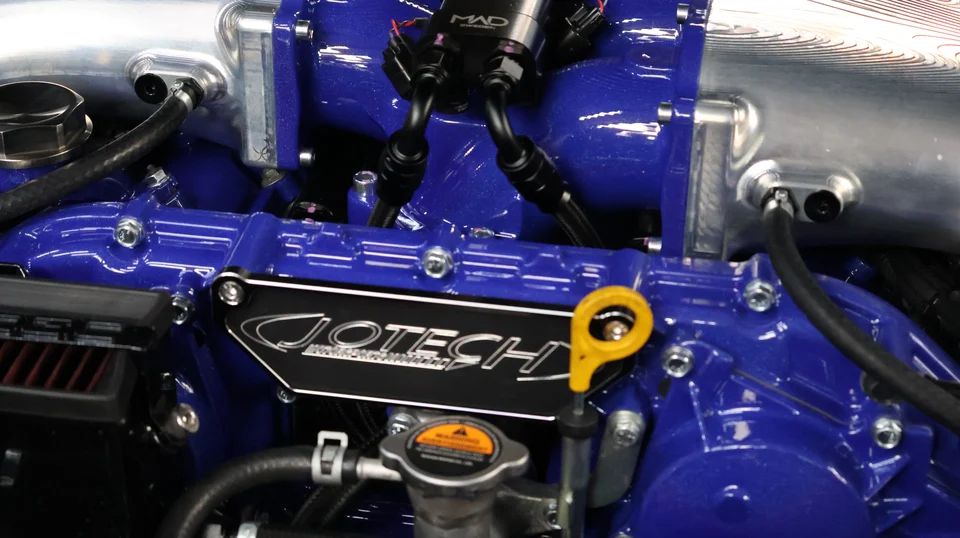 Close-up of a Jotech Motorsports built engine bay featuring a blue intake manifold and MAD performance components.