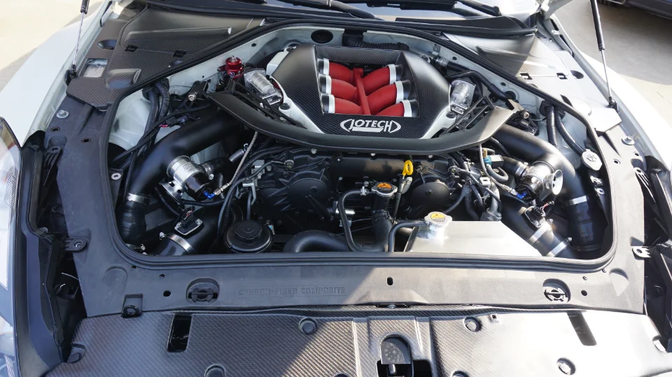 Close-up of a modified Nissan GT-R VR38DETT engine bay with Jotech carbon fiber intake manifold and performance induction system.