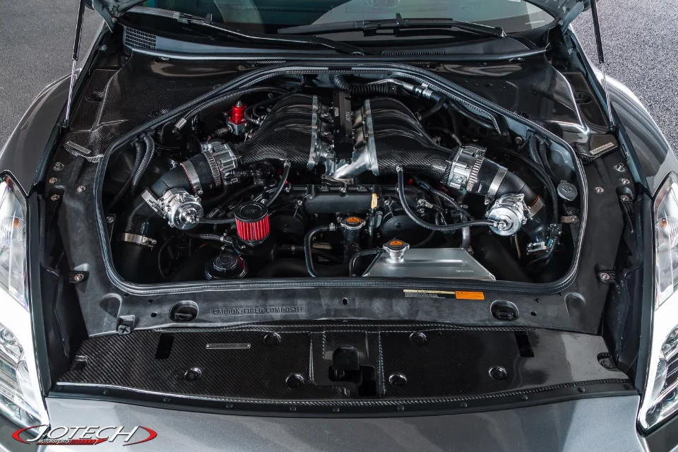 Detailed view of a Jotech-built Nissan GT-R R35 engine bay featuring a carbon fiber intake manifold and aftermarket induction system.