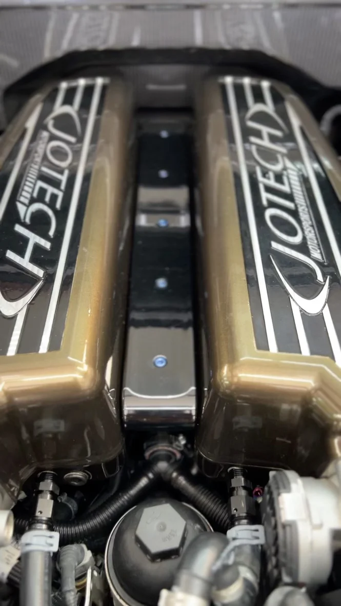 Close-up view of a Jotech branded engine bay with gold valve covers and performance fuel lines.