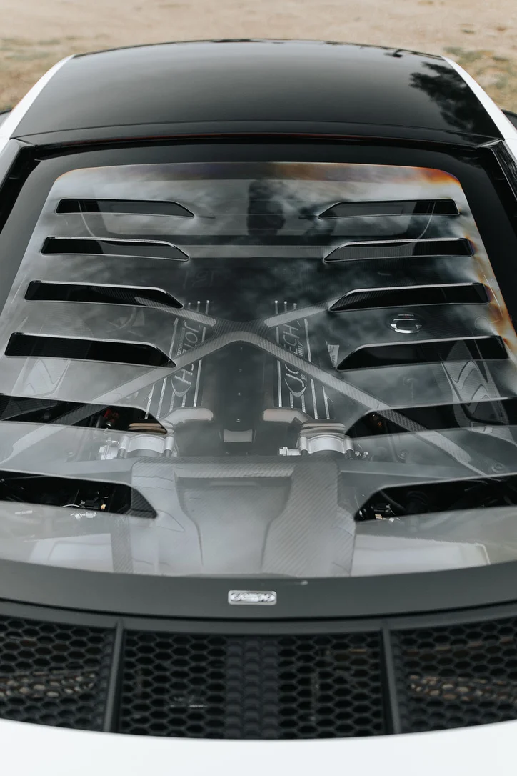 Detailed view of a Jotech-tuned McLaren engine bay, featuring carbon fiber components and custom valve covers.
