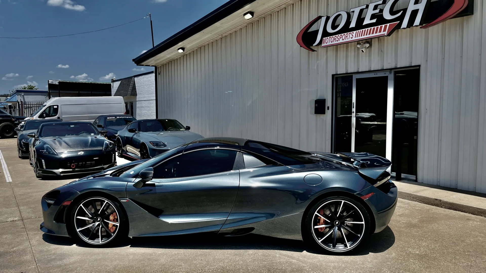 A McLaren 720S, Nissan 370Z, and Nissan Z parked outside the Jotech Motorsports facility on a sunny day.
