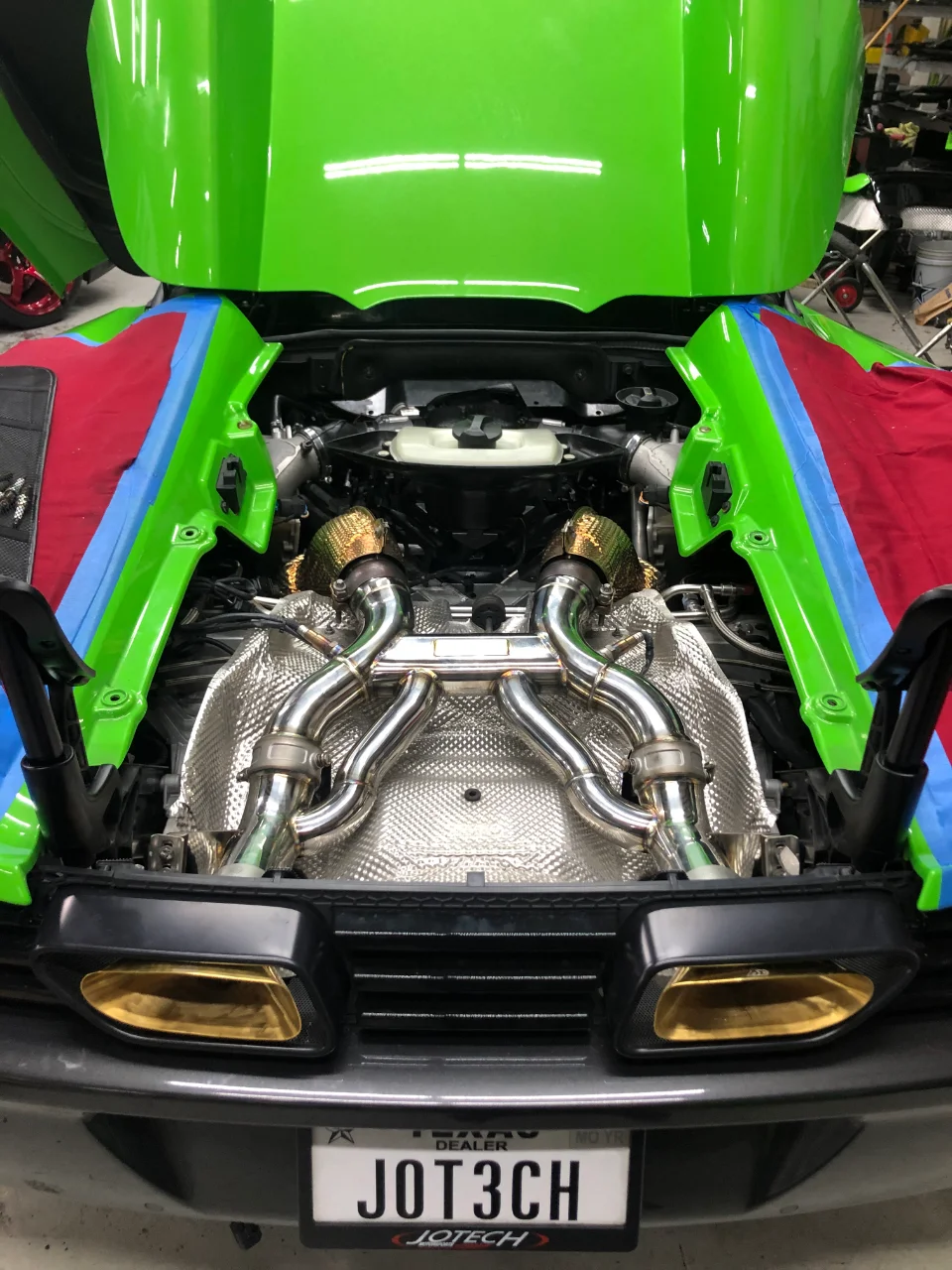 Close-up of a Lamborghini Huracan engine bay with a Jotech twin-turbo exhaust system installed.