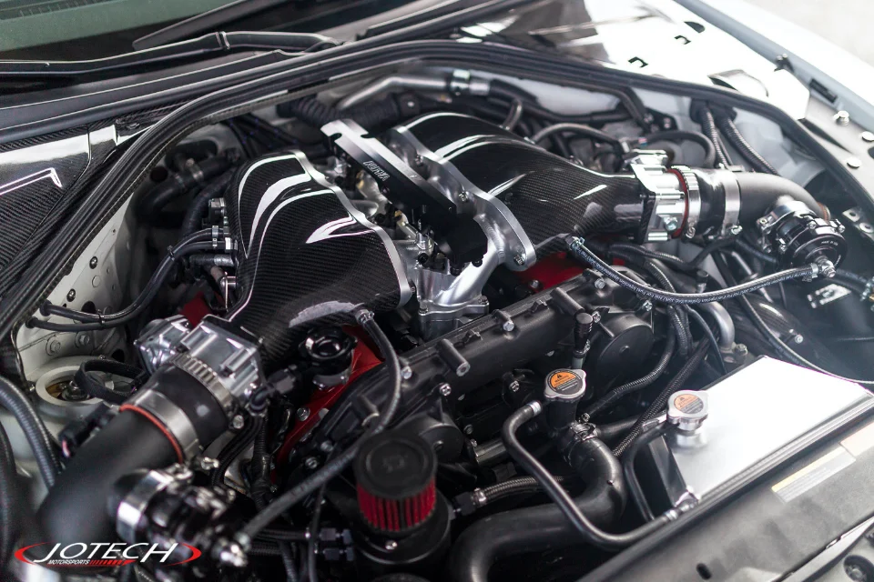 Close-up of a highly modified Nissan GT-R engine bay featuring carbon fiber intake manifolds and performance upgrades by Jotech Motorsports.