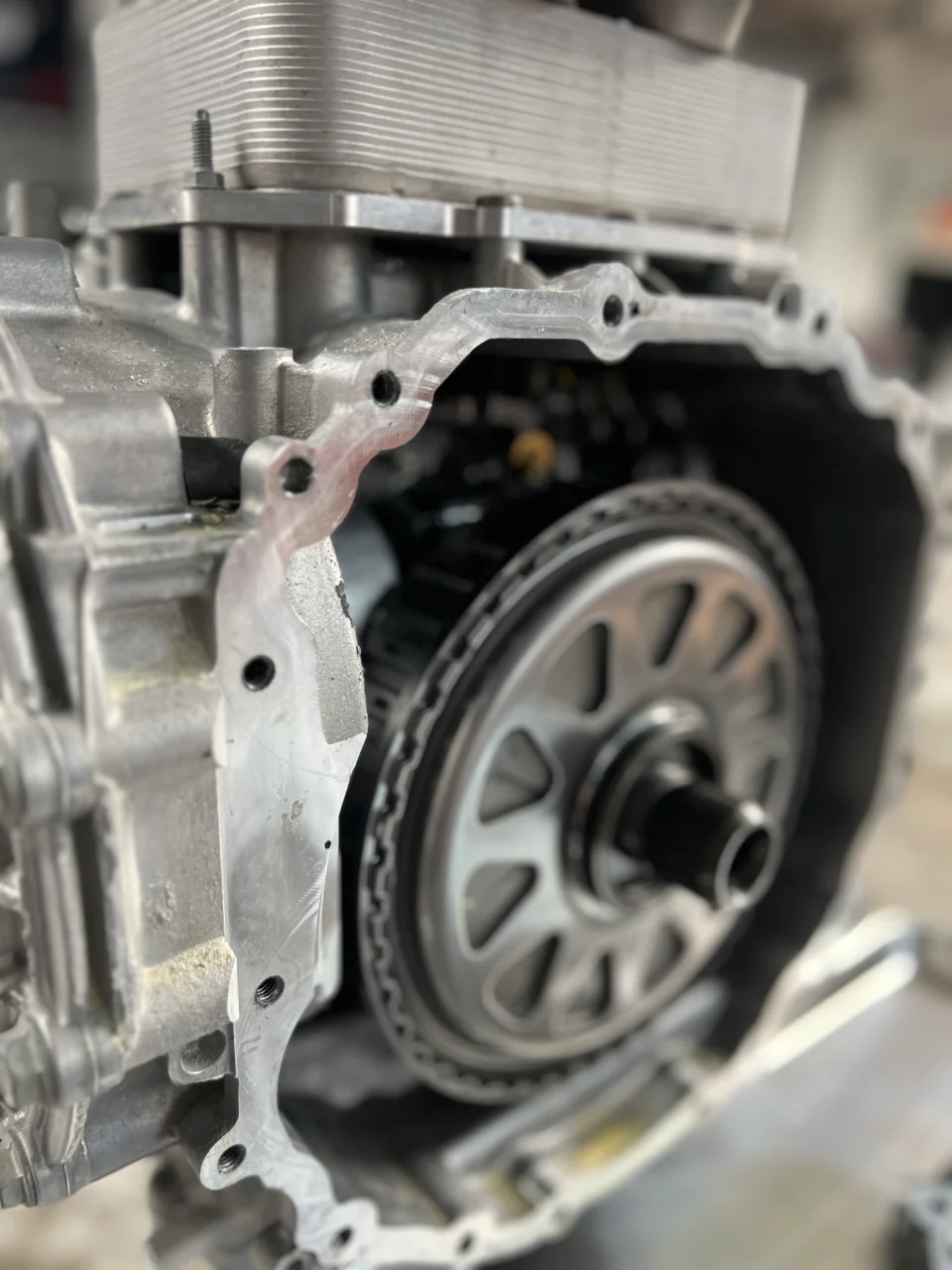 Close-up view of an open transmission case revealing internal gears and drivetrain components during a build or repair at a performance shop.
