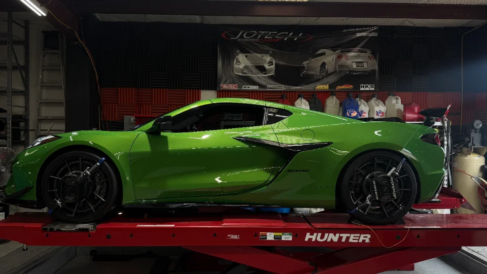 A bright green Chevrolet C8 Corvette strapped onto a Hunter dyno at Jotech Motorsports for performance testing.