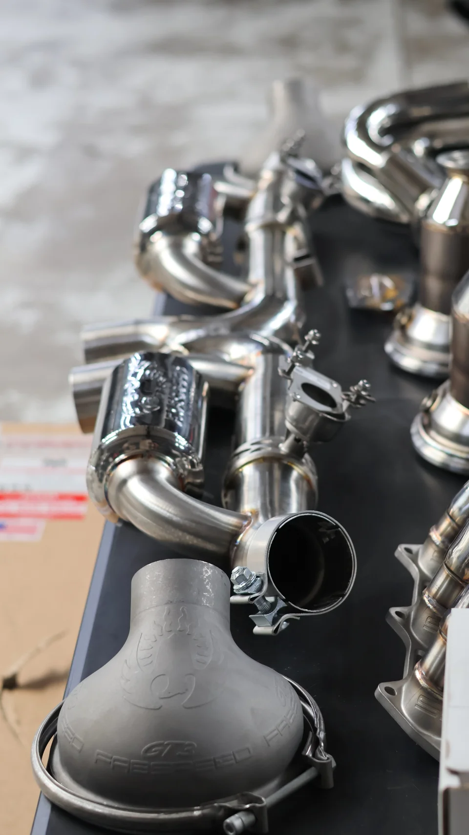 Fabspeed GT3 induction and stainless steel exhaust performance parts displayed on a table.