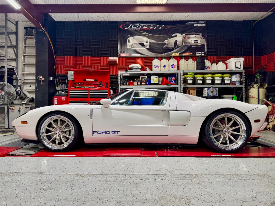 A white Ford GT strapped to a dynamometer at Jotech Motorsports performance tuning shop.