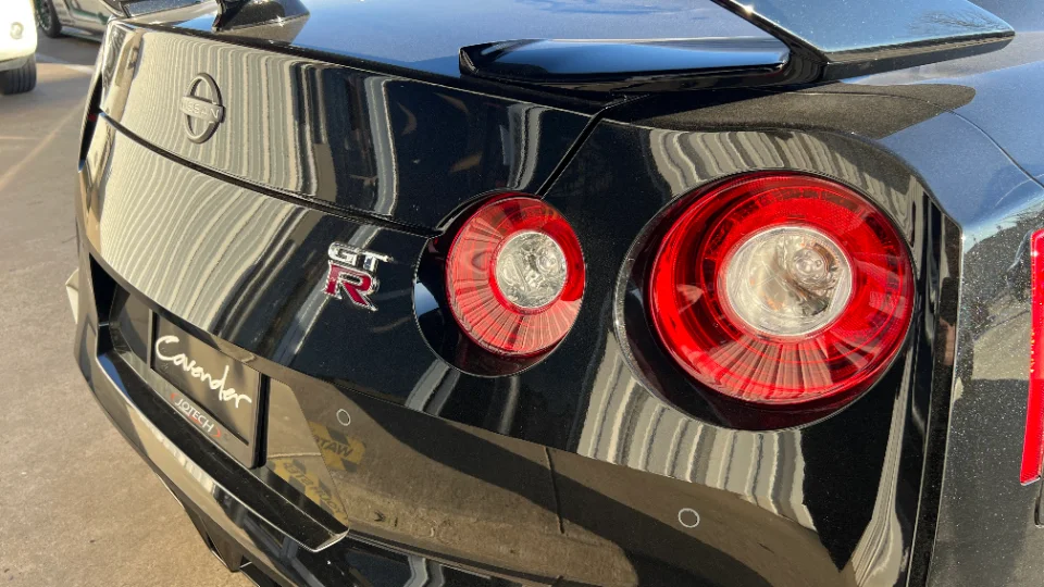 Rear view of a black Nissan GT-R R35 showcasing its iconic taillights and rear spoiler.
