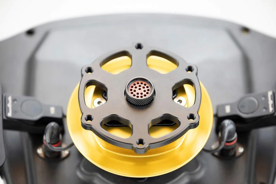 A close-up detail shot of an aftermarket gold and black fuel cap, likely for a performance vehicle.