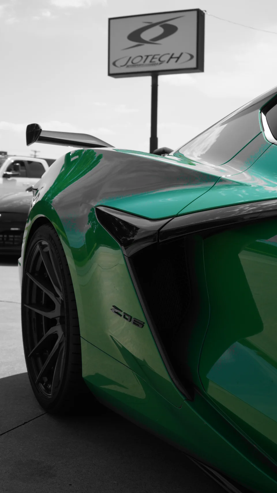 Green Chevrolet Corvette C8 Z06 with a large rear wing parked outside Jotech Motorsports.