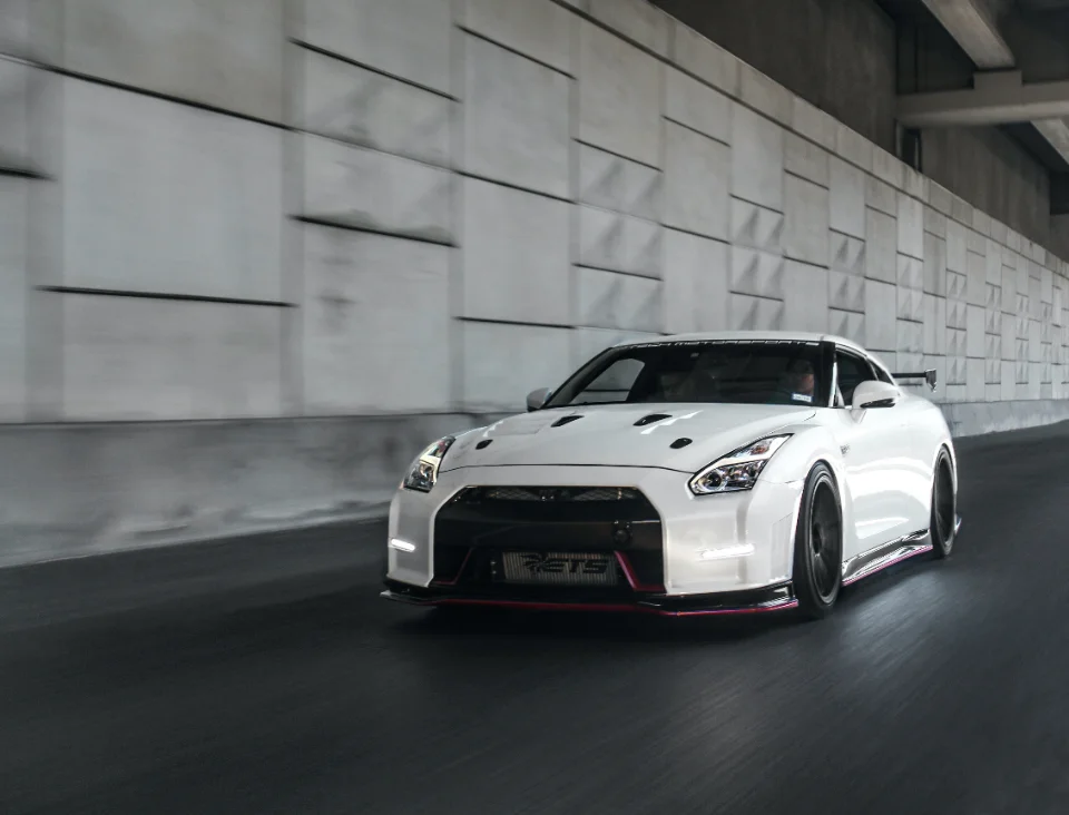 White Nissan GT-R R35 with an ETS intercooler driving through a tunnel, captured in a dynamic roller shot.