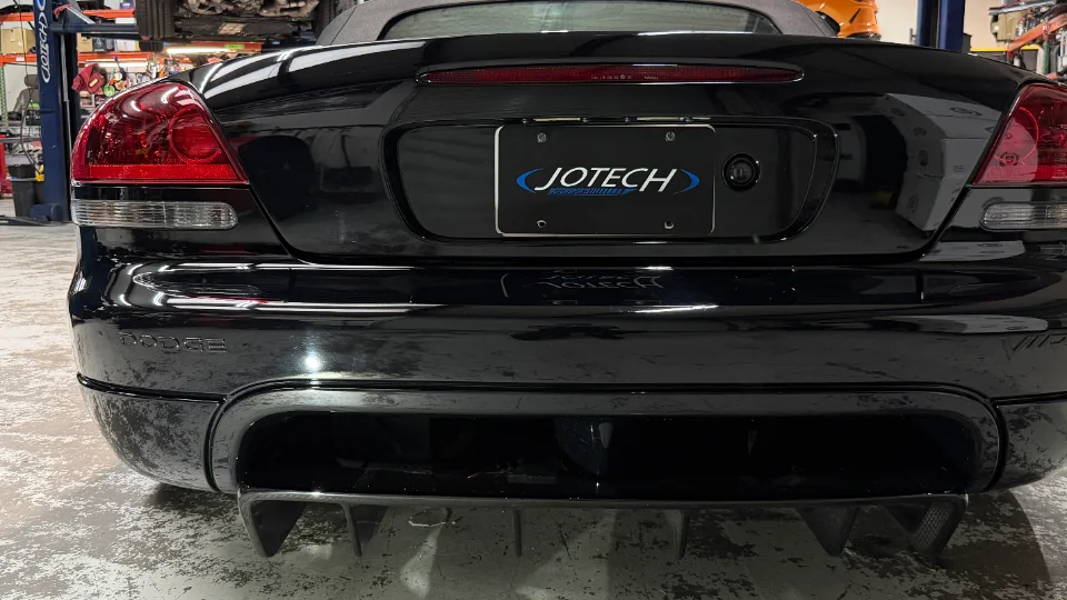 Rear view of a black Dodge Viper with an aftermarket diffuser in a Jotech Motorsports shop.