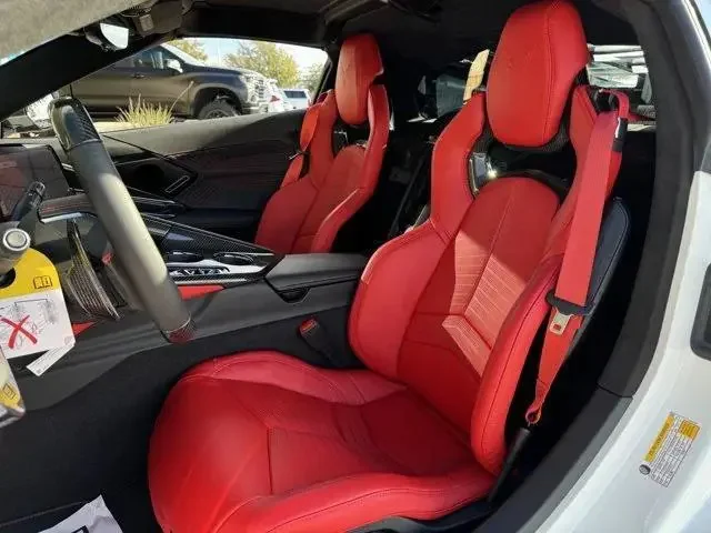Interior view of a C8 Corvette with red leather seats, black and red trim, and a steering wheel.