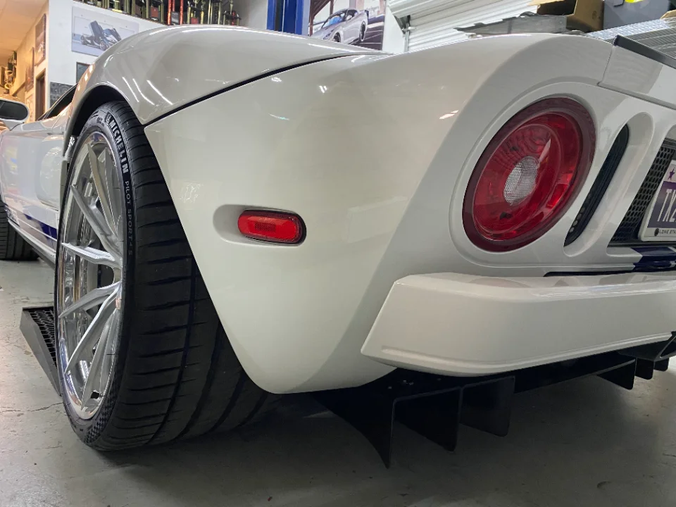 Rear view of a white Ford GT showcasing custom wheels with Michelin tires and an aggressive aftermarket rear diffuser.