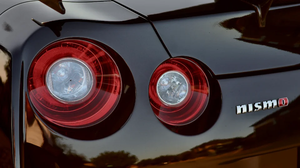 Close-up of the rear taillights and Nismo badge on a black Nissan GT-R.