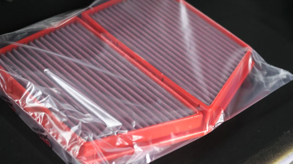 New performance air filters in red, still in their clear plastic packaging.