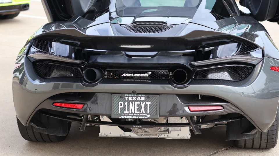Rear view of a grey McLaren 720S showcasing its carbon fiber active aero wing, diffuser, and dual exhaust tips.