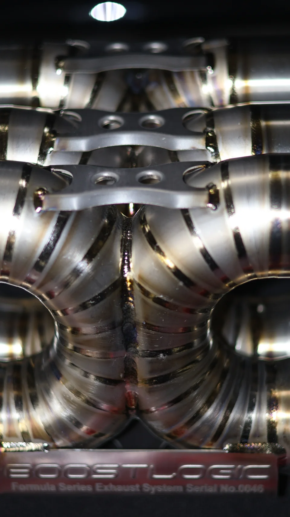 Close-up of a BoostLogic Formula Series stainless steel exhaust system with intricate welds.