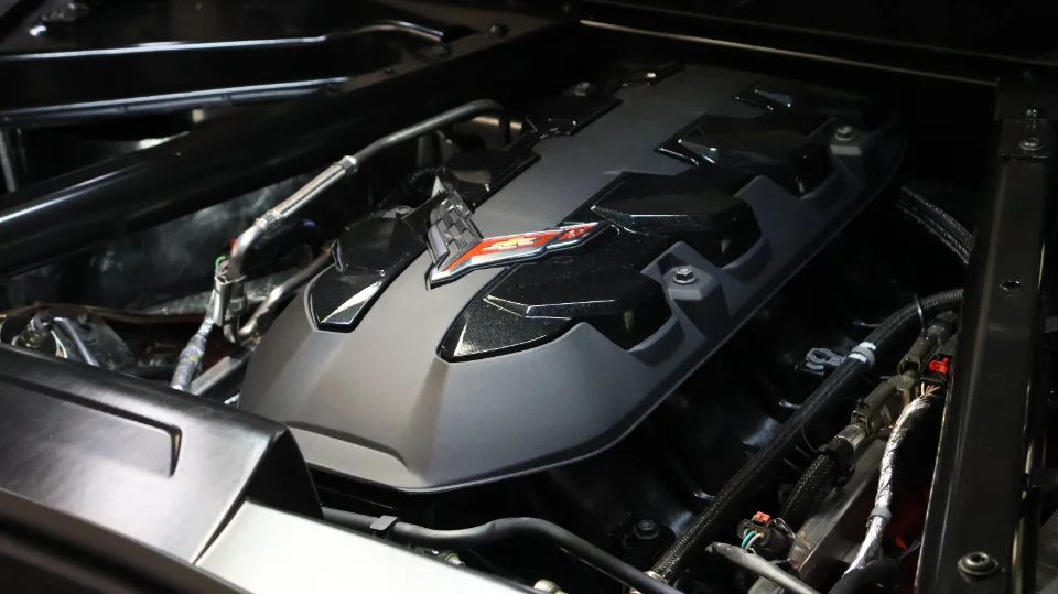 Close-up view of a Chevrolet Corvette C8 LT2 engine bay with the engine cover and wiring visible.