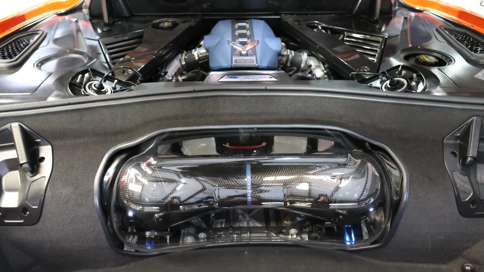 Close-up view of a Corvette C8 LT2 engine bay featuring an aftermarket carbon fiber intake system.