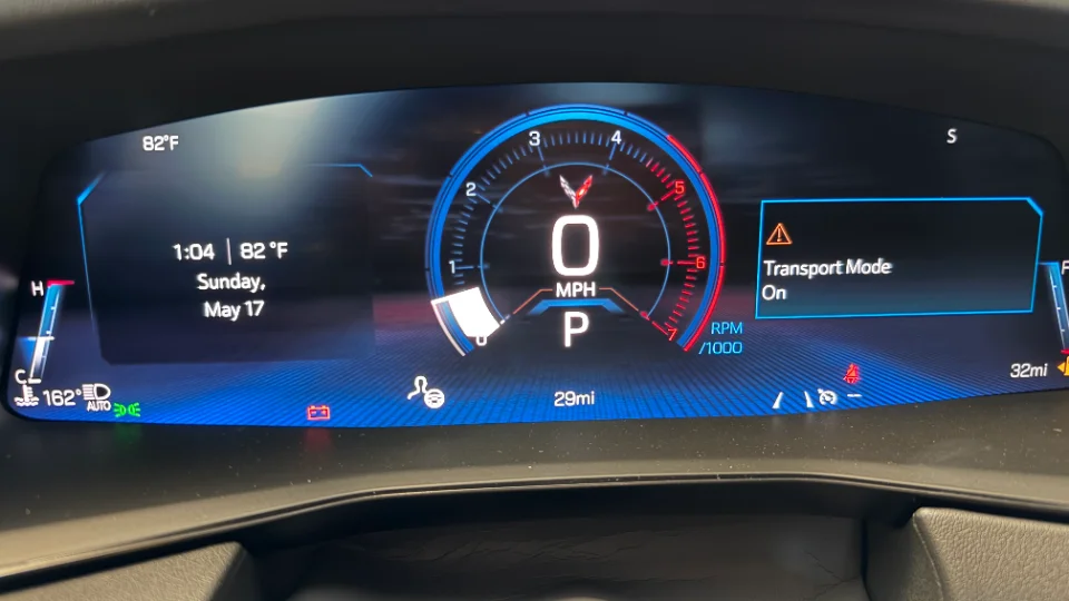 Digital dashboard of a Corvette C8 showing speed, RPM, temperature, and 'Transport Mode On' message.